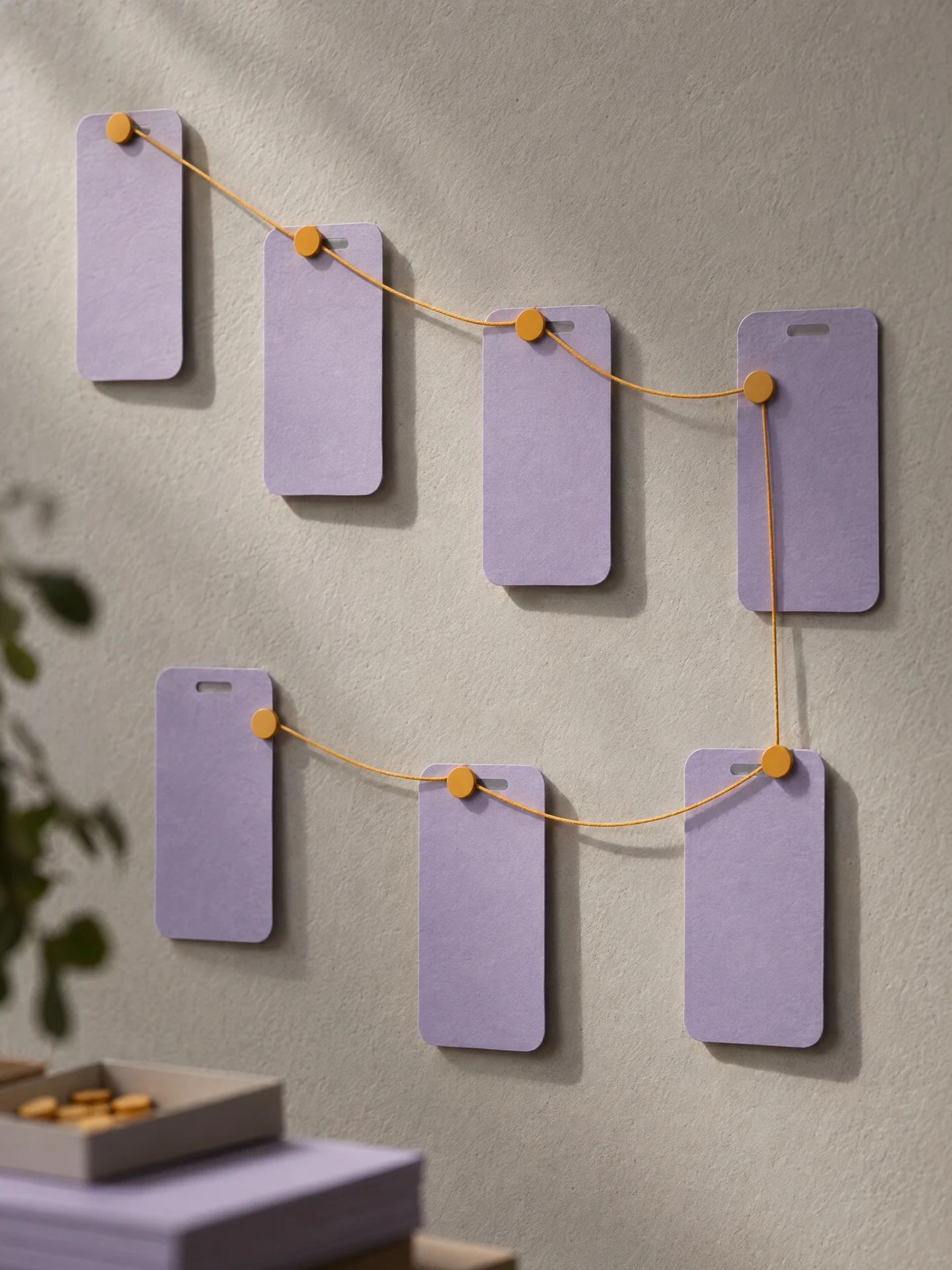Blank mobile paper screens connected by colored thread as a journey map